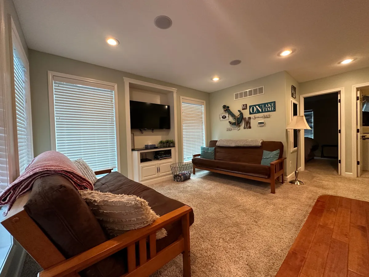 A comfortable living area with a plush sofa, decorative throw pillows, a television unit, and wall art. The space is cozy, inviting, and ideal for relaxation or socializing, reflecting a secure and homey atmosphere.