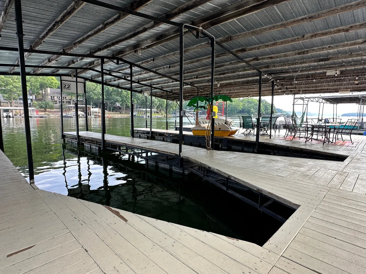 This image depicts a tranquil wooden dock extending over the water, with a yellow boat moored at the side and a small, inviting seating area. The setting evokes a sense of peacefulness and connection to the lakeside environment, ideal for relaxing or enjoying outdoor activities.