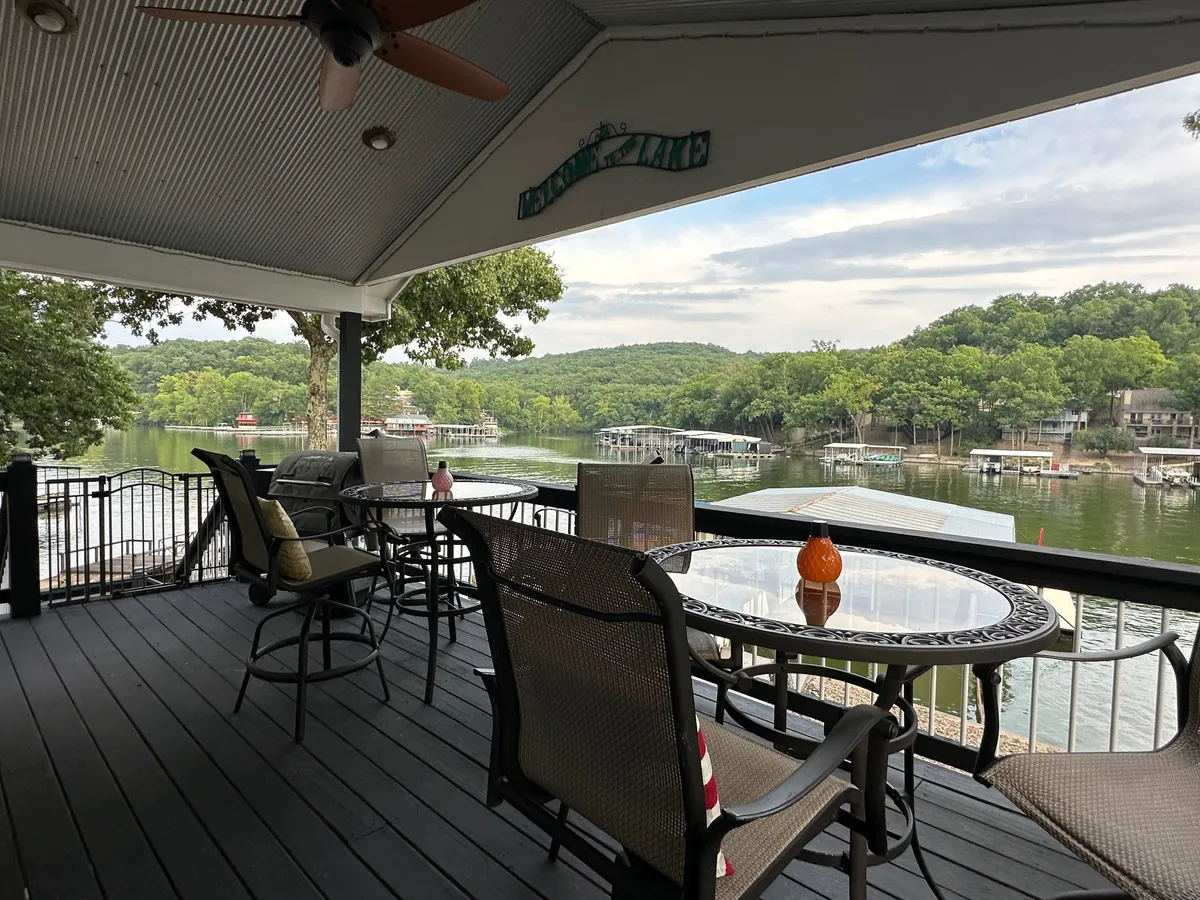The hero image captures a serene outdoor seating area overlooking the tranquil lake, accented with a decorative pumpkin, inviting guests to relax, dine, and savor breathtaking sunset views. The golden sky reflects off the water, creating a warm and inviting atmosphere perfect for gathering with friends or family.